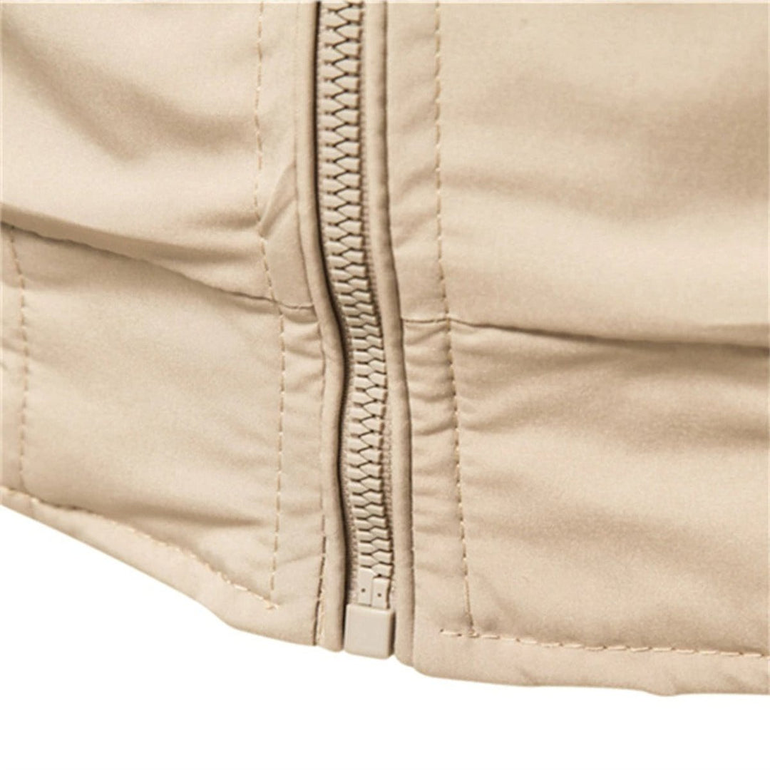 Close-up of zipper and hem ribbed trim on beige bomber jacket