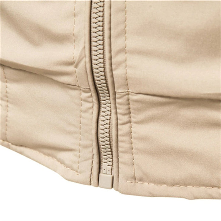 Close-up of zipper and hem ribbed trim on beige bomber jacket
