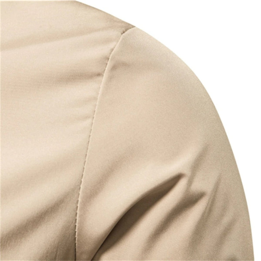 Close-up of shoulder seam detail on beige bomber jacket