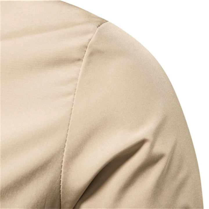 Close-up of shoulder seam detail on beige bomber jacket